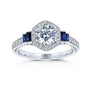 Blue sapphire stepped side stones next to a rounded hexagonal halo and round center stone