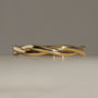 Polished yellow gold twisted infinity-style band ring, shown on a neutral light gray background. Note, the twist does not continue all the way around the ring (the shank along the bottom is flat to allow for any future resizing needs).