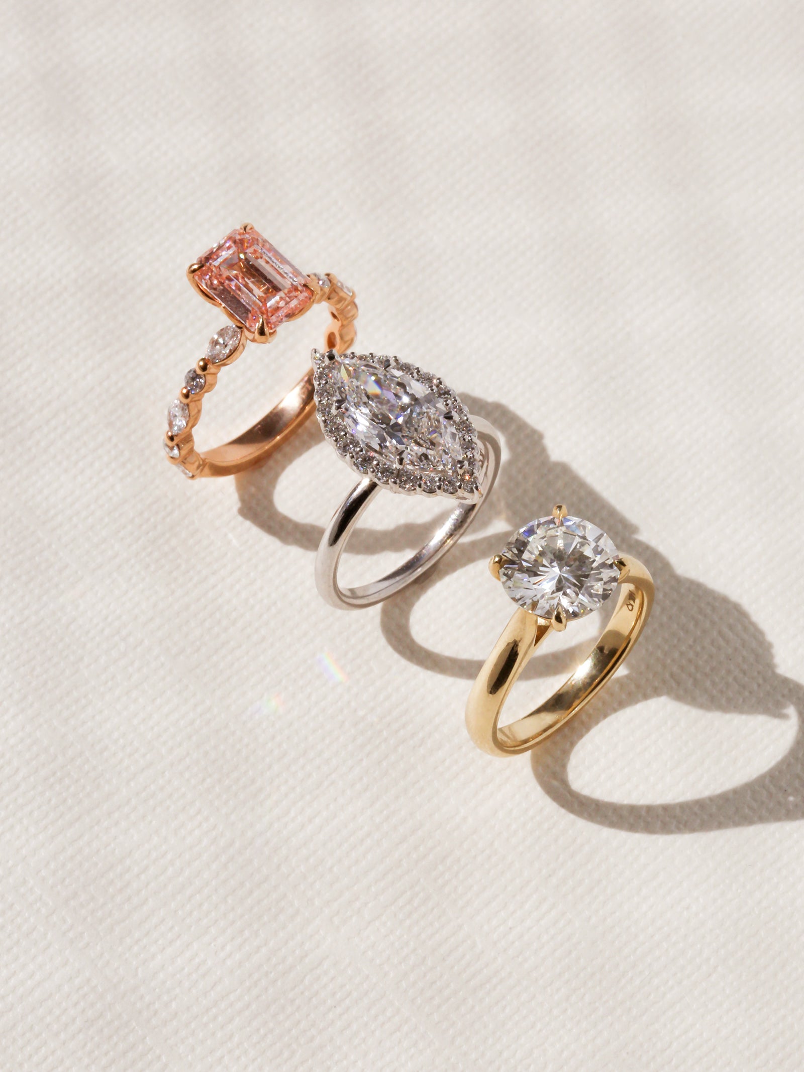 Three Kobelli one-of-a-kind rings standing on a white cardstock paper