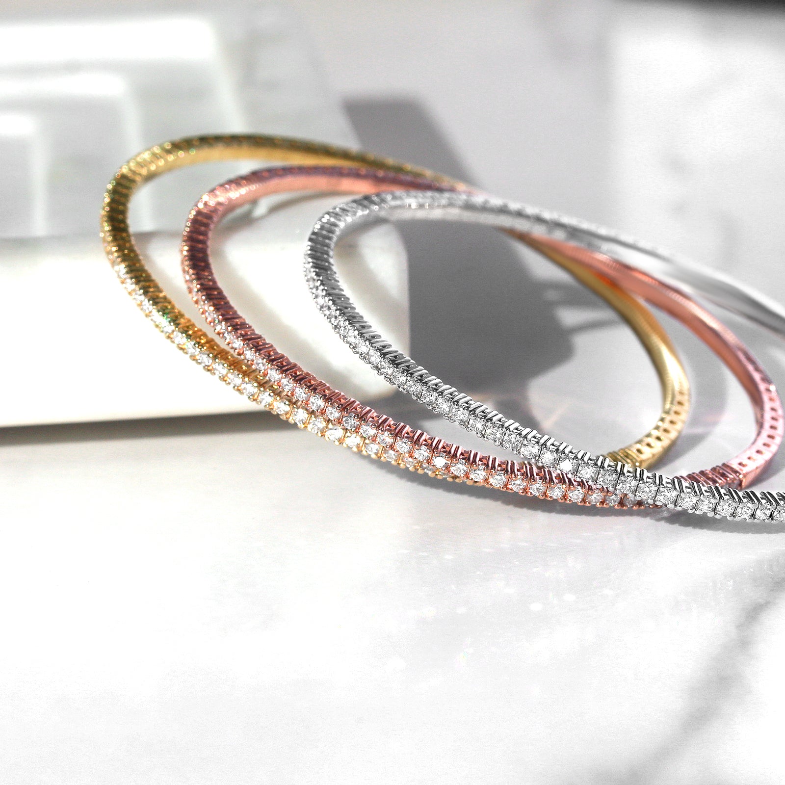 Stack of diamond bangles on marble surface