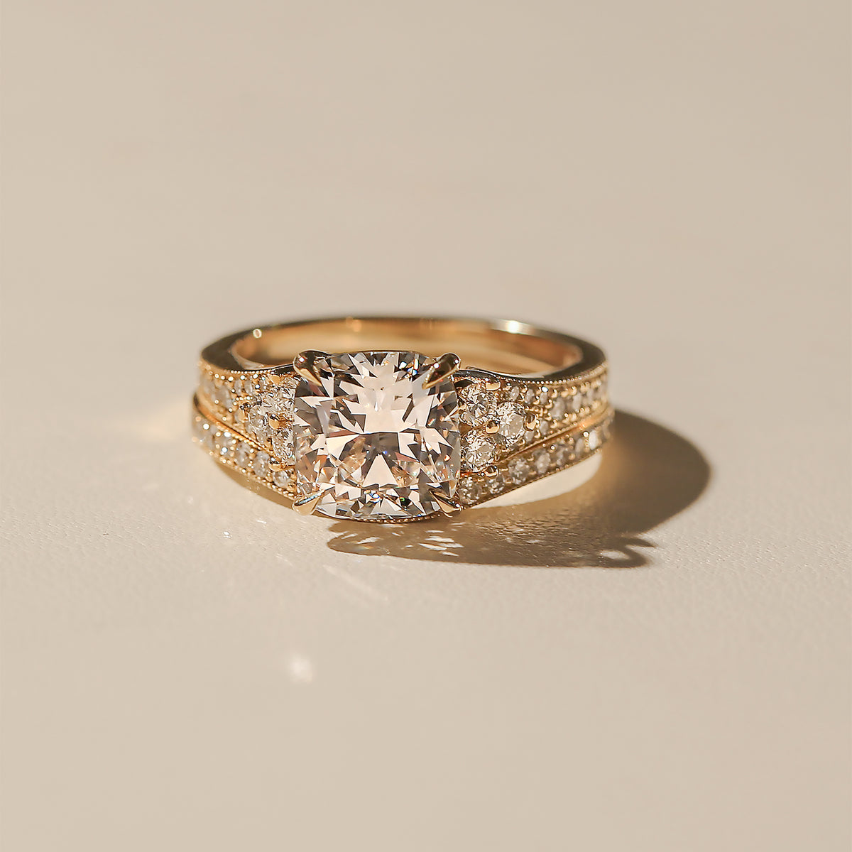 Lifestyle image of the Kobelli Grindelwald 2 Piece Bridal Set - Both rings stacked together; showcases a large cushion brilliant-cut center diamond and pavé-set accent diamonds in solid 14-karat gold - yellow gold option in size 7.5, 3 carat center diamond