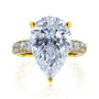 The Beckham Ring in Yellow Gold - massive pear-cut white diamond center stone with multiple rows of round white diamonds lining the band
