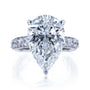 The Beckham Ring in White Gold - massive pear-cut white diamond center stone with multiple rows of round white diamonds lining the band