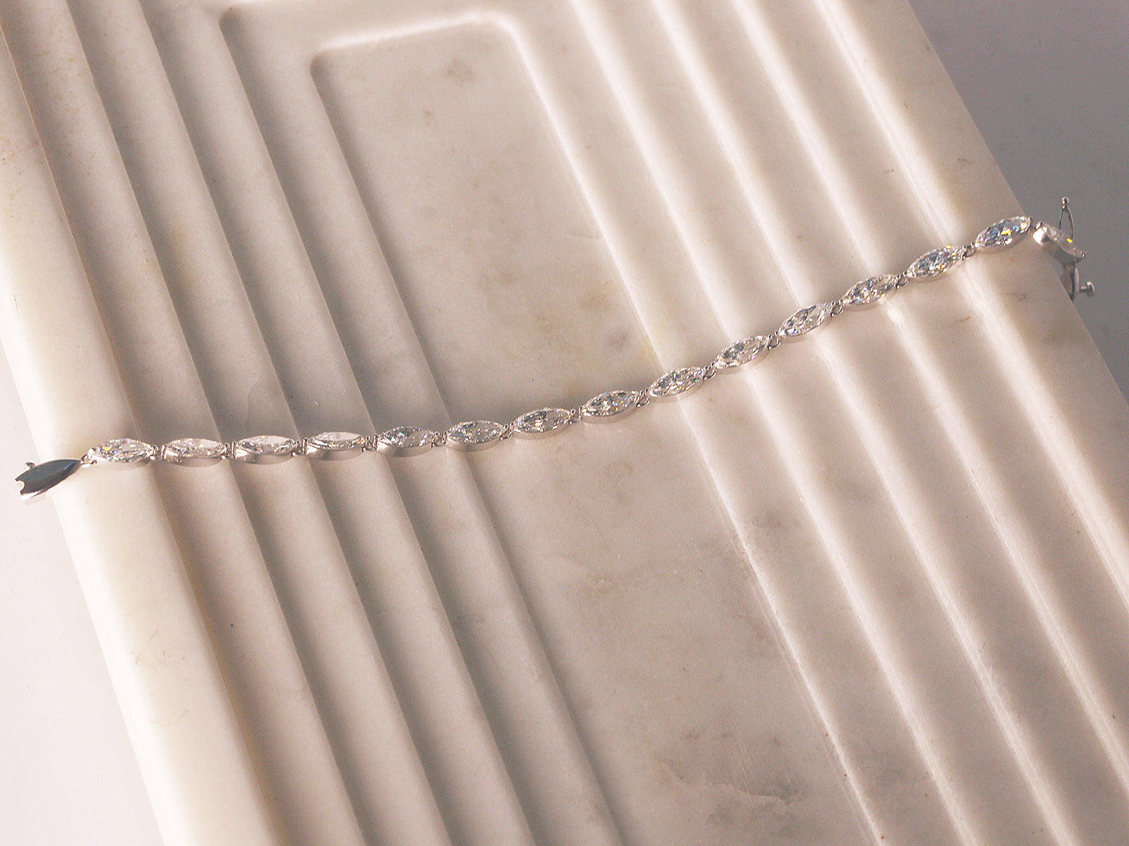 marquise diamond tennis bracelet - lifestyle image laid on off-white display plate