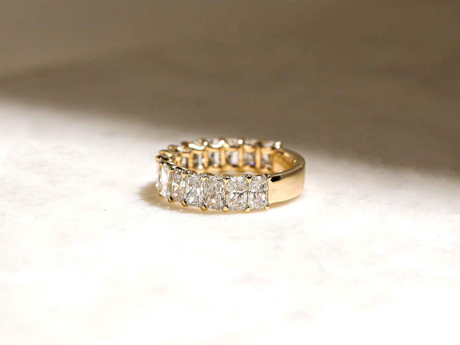 lifestyle image of ring on white table sitting under diffused sunlight