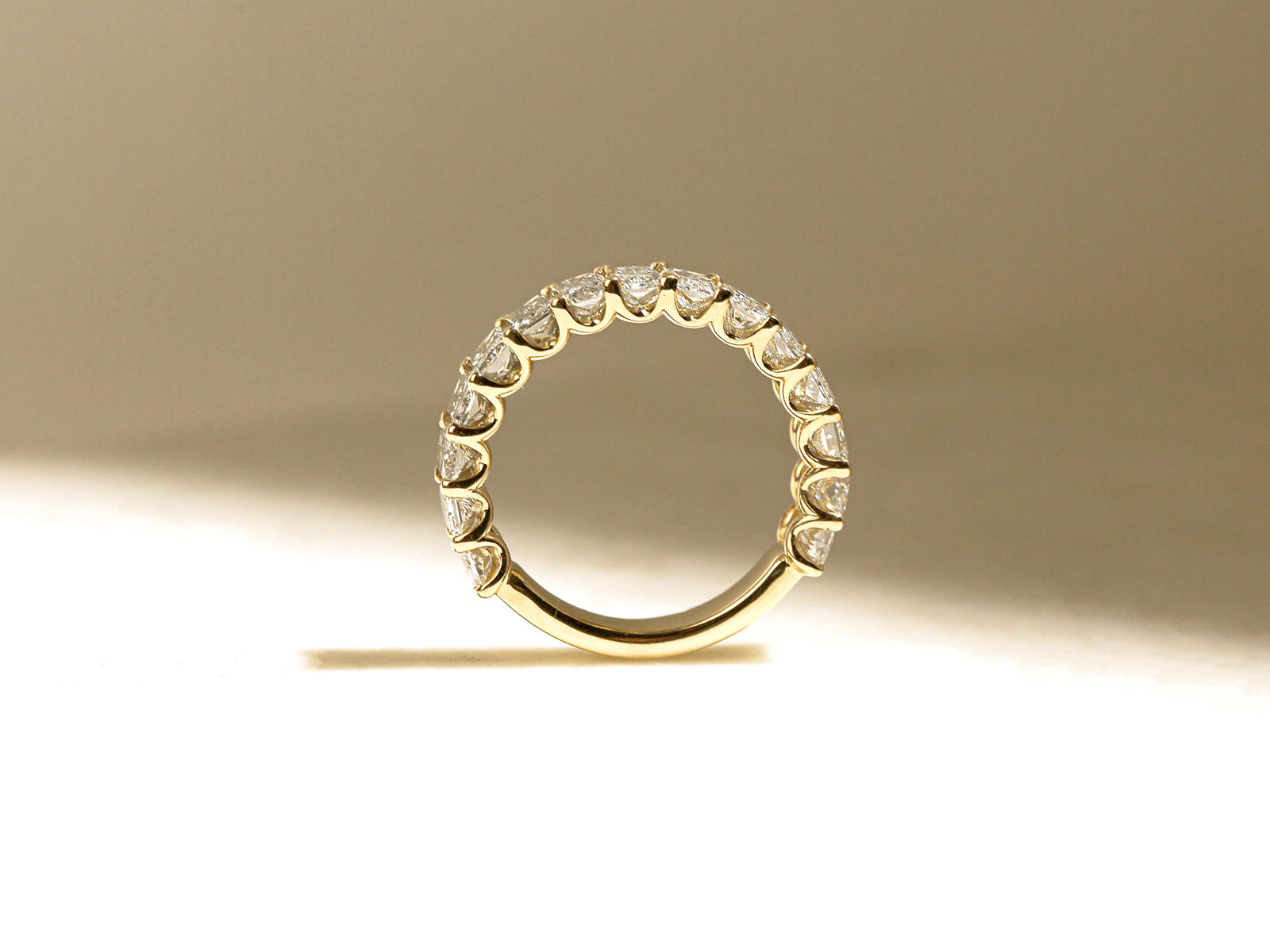 lifestyle image of ring standing upright on white table under diffused sunlight