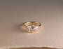 lifestyle image of old mine-cut diamond ring laid flat on an off-white thick woven cardstock sheet