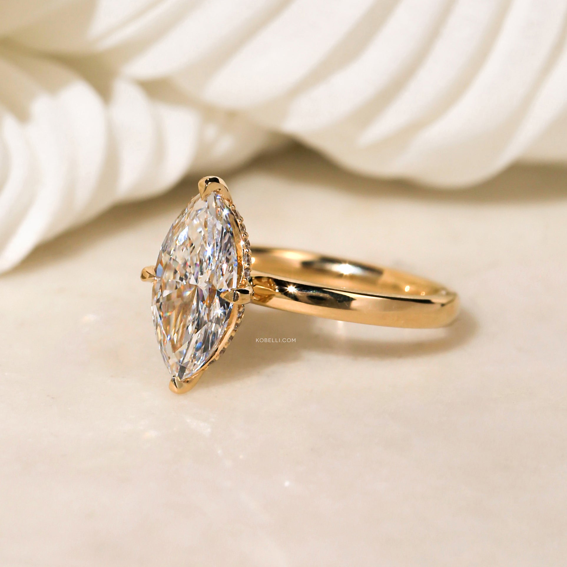 Four prongs carry the center stone in NESW setting