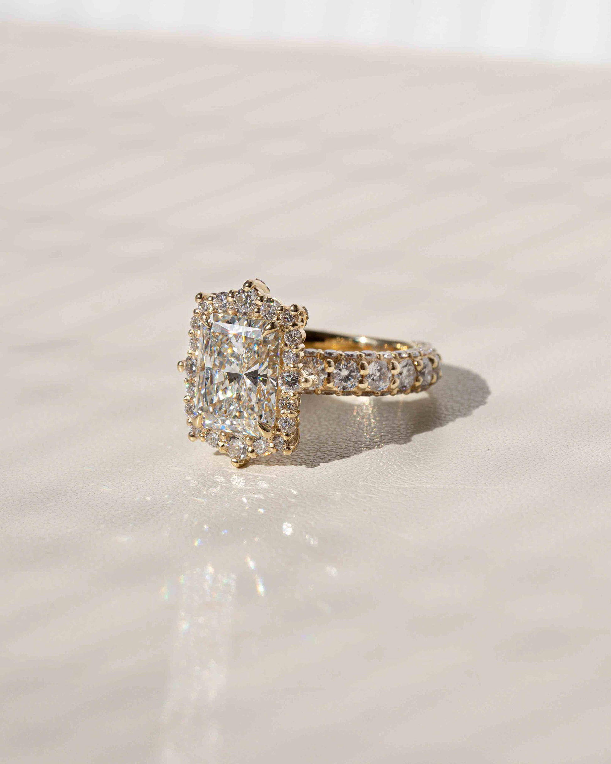 Rococo halo offers a gorgeous frame to your radiant-cut center diamond
