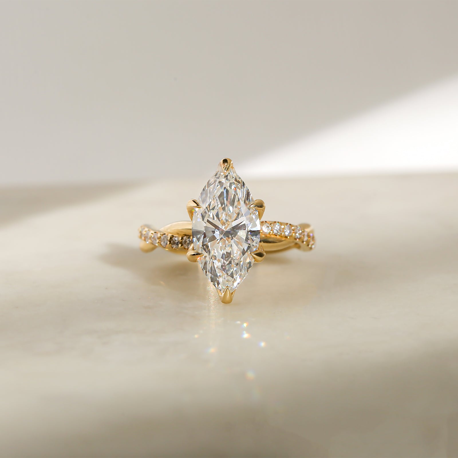 3.25 Carat Lab Grown Diamond Marquise Shifting Helix Ring - front angle resting on a marbled white table