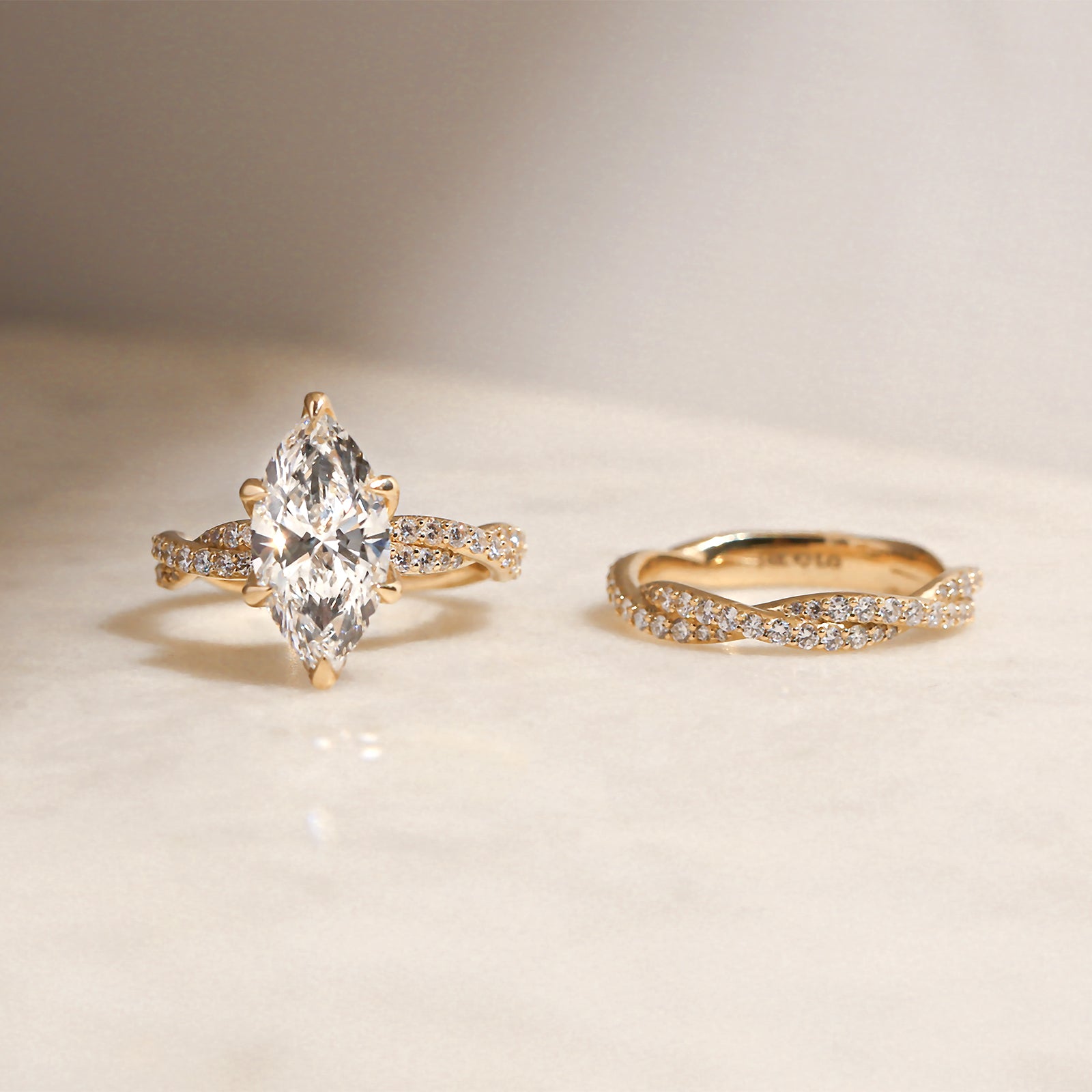 3.5 Carat Lab Grown Diamond Marquise Double Helix Ring Solid 14k Yellow Gold Matched to the Double Helix Wedding Band - lifestyle image resting on a table in indirect sunlight