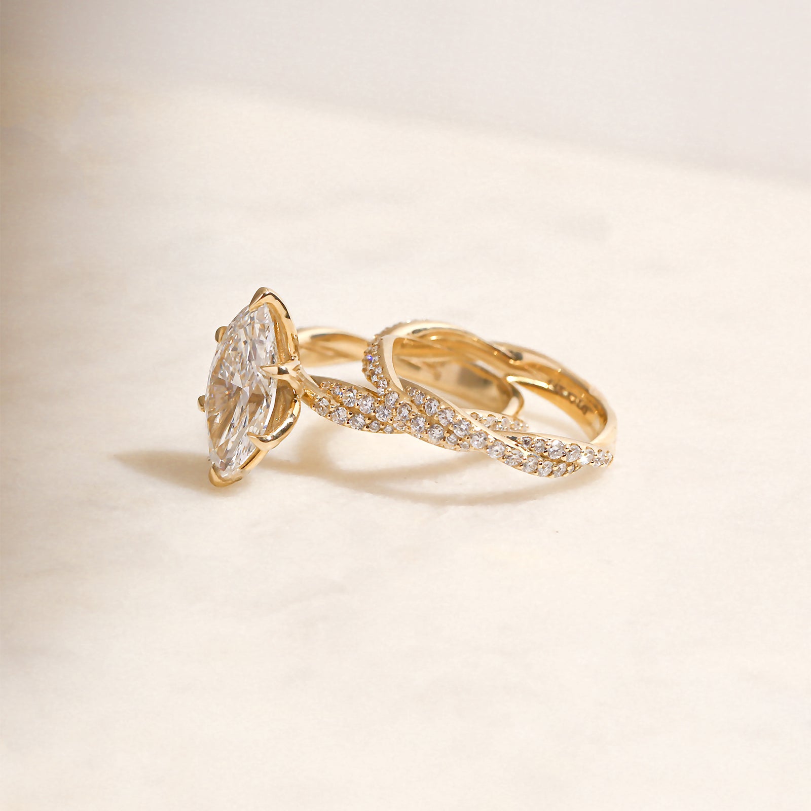 3.5 Carat Lab Grown Diamond Marquise Double Helix Ring Solid 14k Yellow Gold paired to the Diamond Double Helix Wedding Band - lifestyle image resting on a white surface