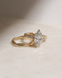 3.5 Carat Lab Grown Diamond Marquise Double Helix Ring Solid 14k Yellow Gold hovering over the Plain Gold Helix Wedding Band - lifestyle image resting on a table in indirect sunlight