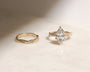 3.5 Carat Lab Grown Diamond Marquise Double Helix Ring Solid 14k Yellow Gold paired to the Plain Gold Helix Wedding Band - lifestyle image resting on a table in indirect sunlight
