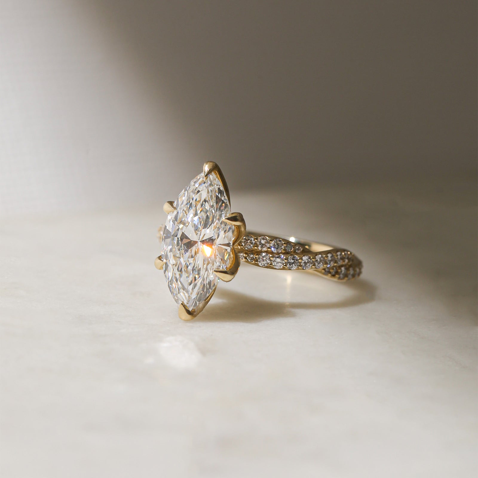 3.5 Carat Lab Grown Diamond Marquise Double Helix Ring Solid 14k Yellow Gold - lifestyle image resting on a table in indirect sunlight