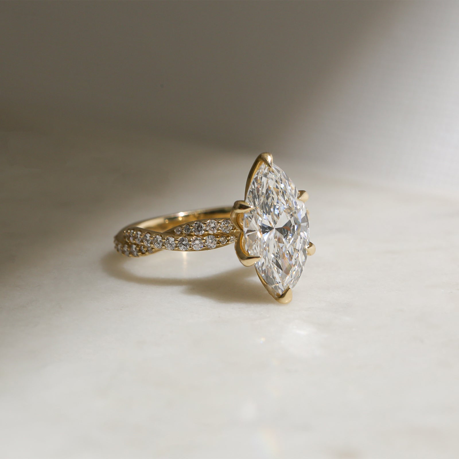 3.5 Carat Lab Grown Diamond Marquise Double Helix Ring Solid 14k Yellow Gold - lifestyle image resting on a table in indirect sunlight