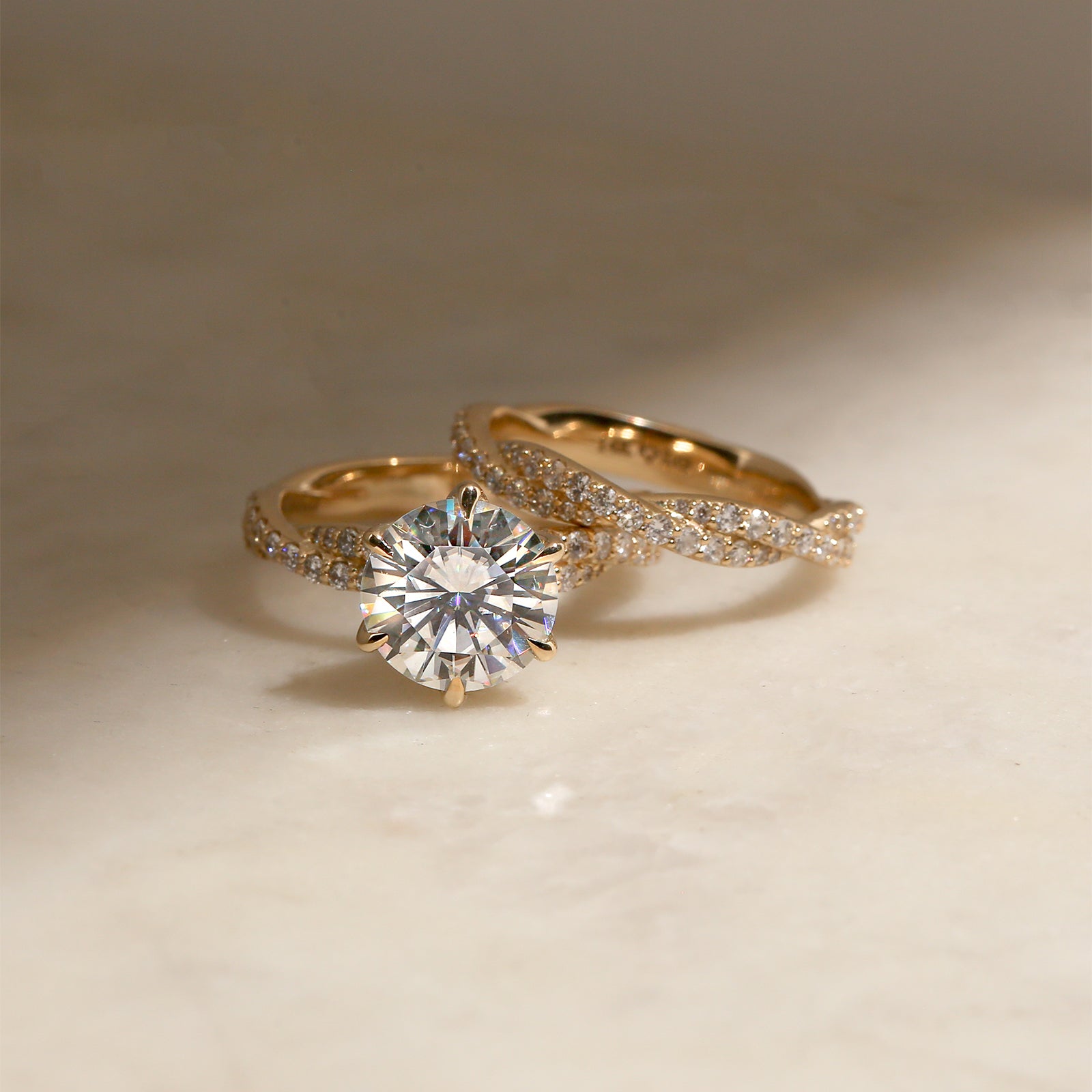 lifestyle image of the Round Diamond Double Helix Engagement Ring with the Diamond Double Helix Wedding Band leaning on one side of it