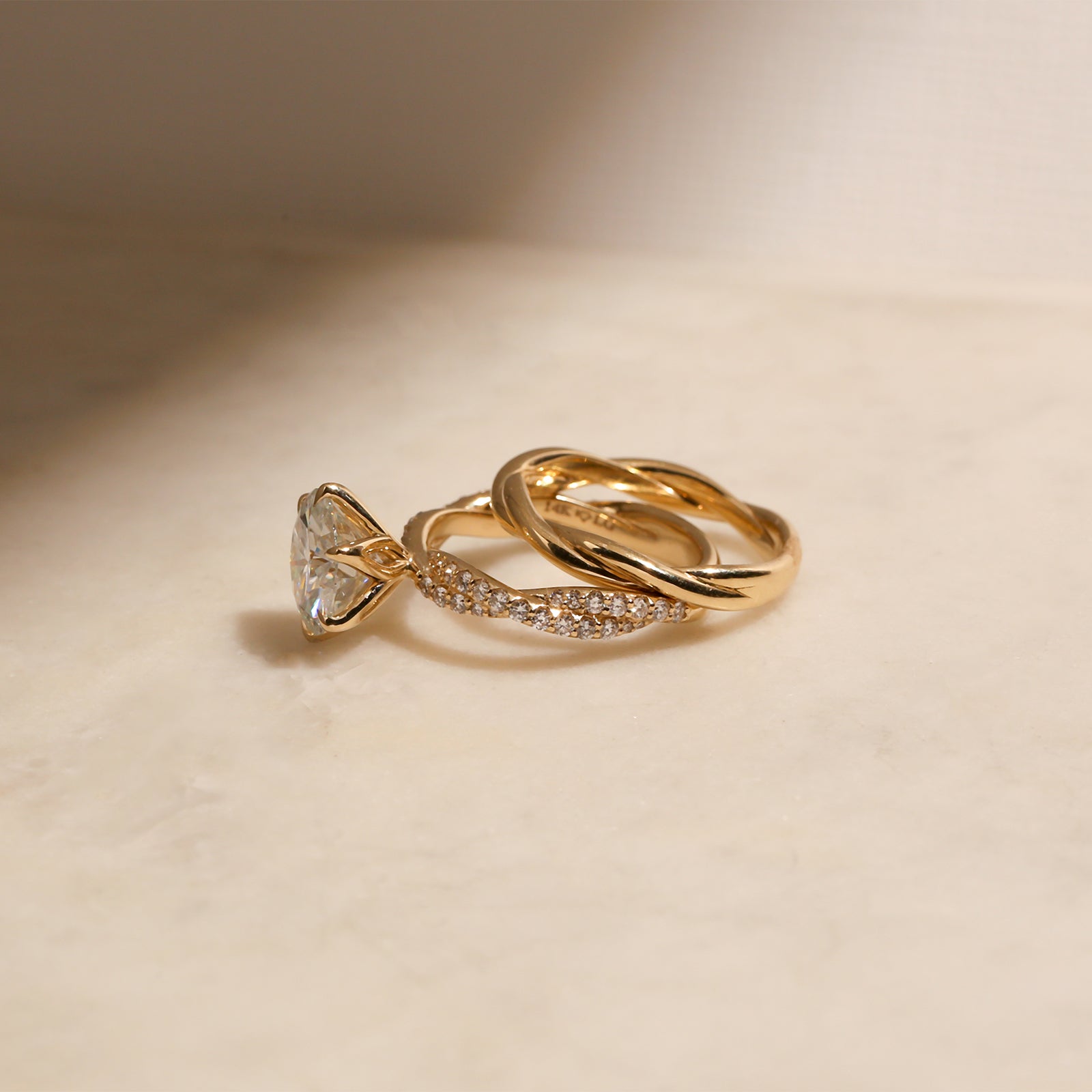lifestyle image of the Round Diamond Double Helix Engagement Ring sitting under the Plain Helix Wedding Band, shot at a full side angle