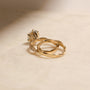lifestyle image of the Round Diamond Double Helix Engagement Ring sitting under the Plain Helix Wedding Band, shot at a back angle to showcase the design