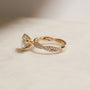 lifestyle image of the Double Helix Round Diamond Ring resting on a white table, shot at a full side angle