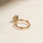 lifestyle image of the Double Helix Round Diamond Ring resting on a table, shot from the backside of the ring to showcase the design under the center setting