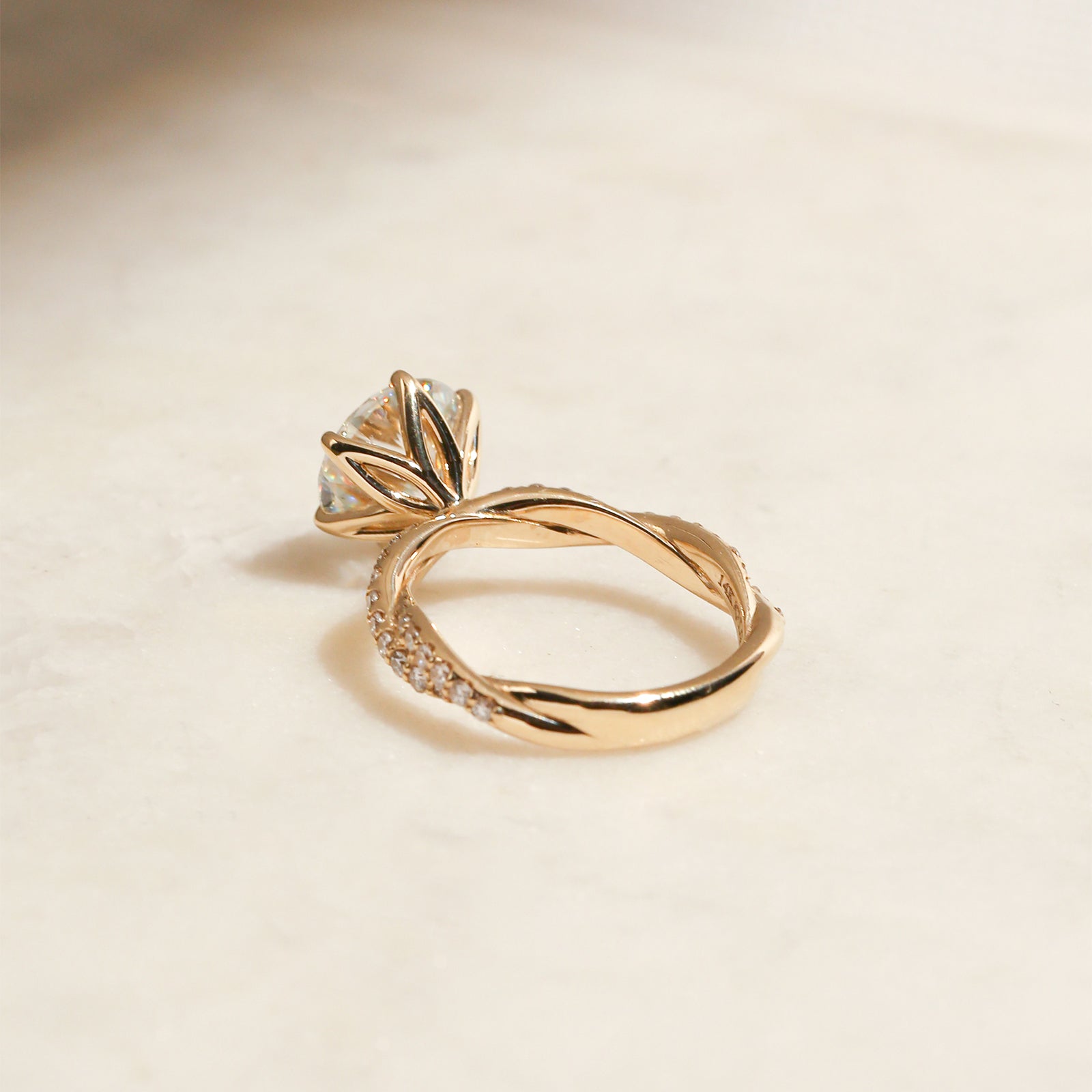 lifestyle image of the Double Helix Round Diamond Ring resting on a table, shot from the backside of the ring to showcase the design under the center setting