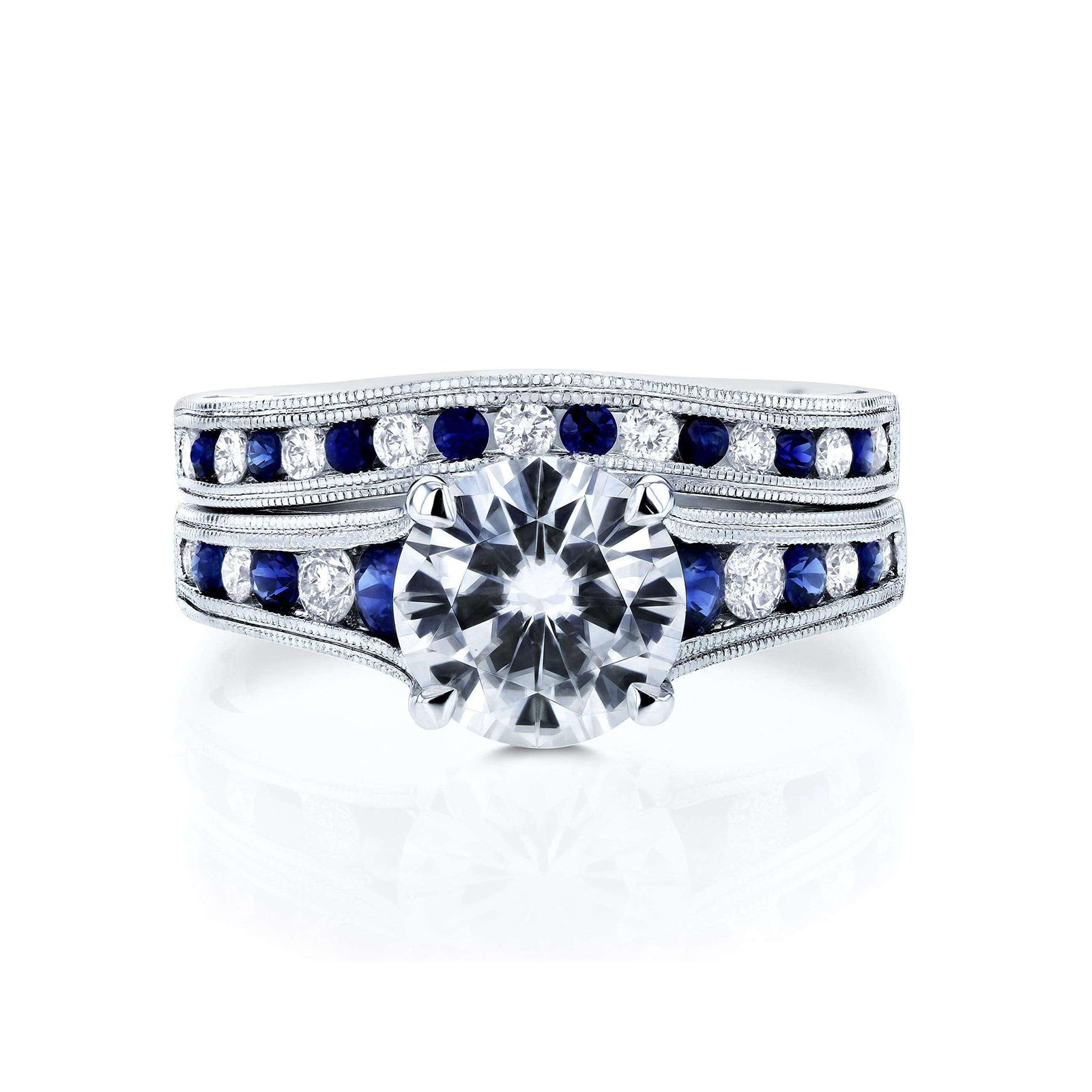 A solid 14k white gold engagement ring and wedding band set with a large round brilliant-cut center moissanite, channel-set round white diamonds and deep blue sapphires
