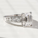 Anel de noivado de moissanite esmeralda Kobelli e diamantes redondos de fileira tripla
