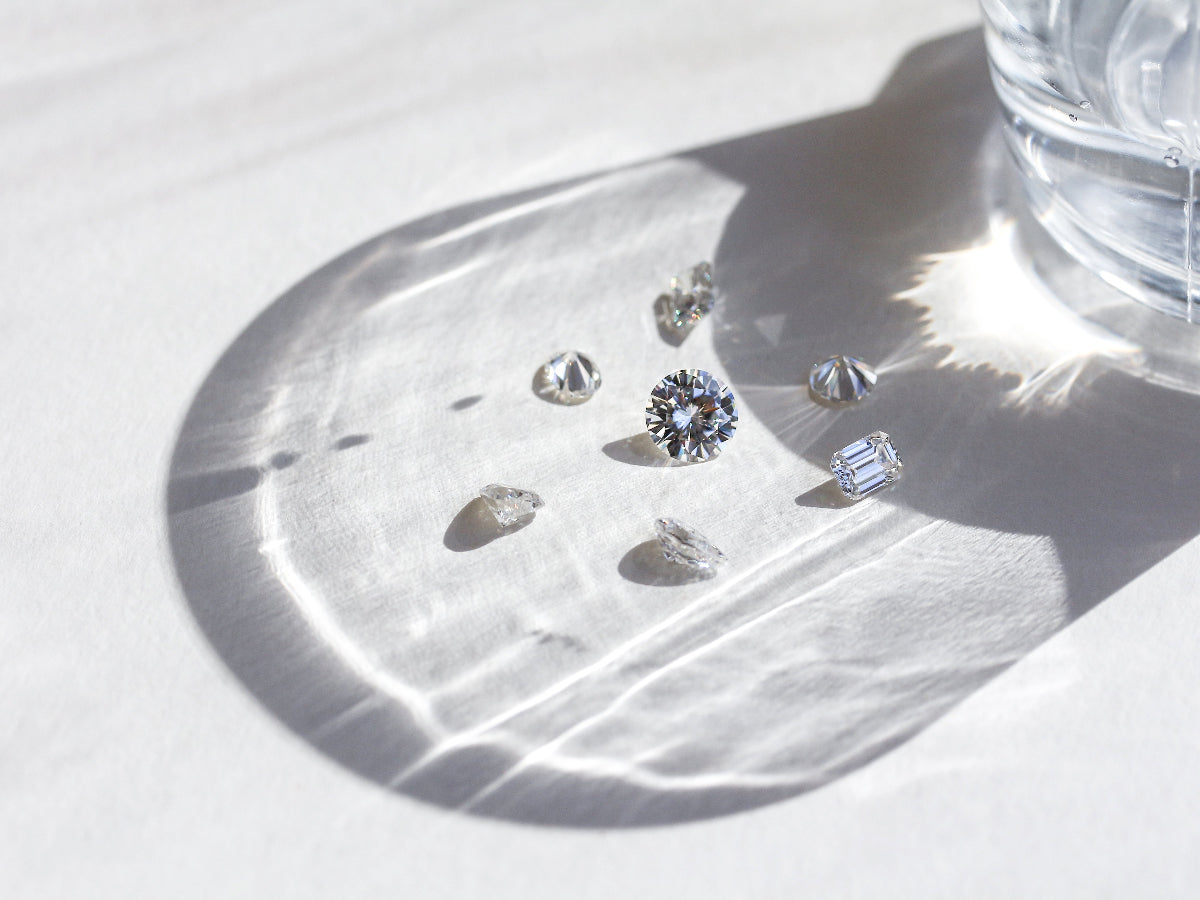 loose diamonds - round and emerald-cut shining in glassy light