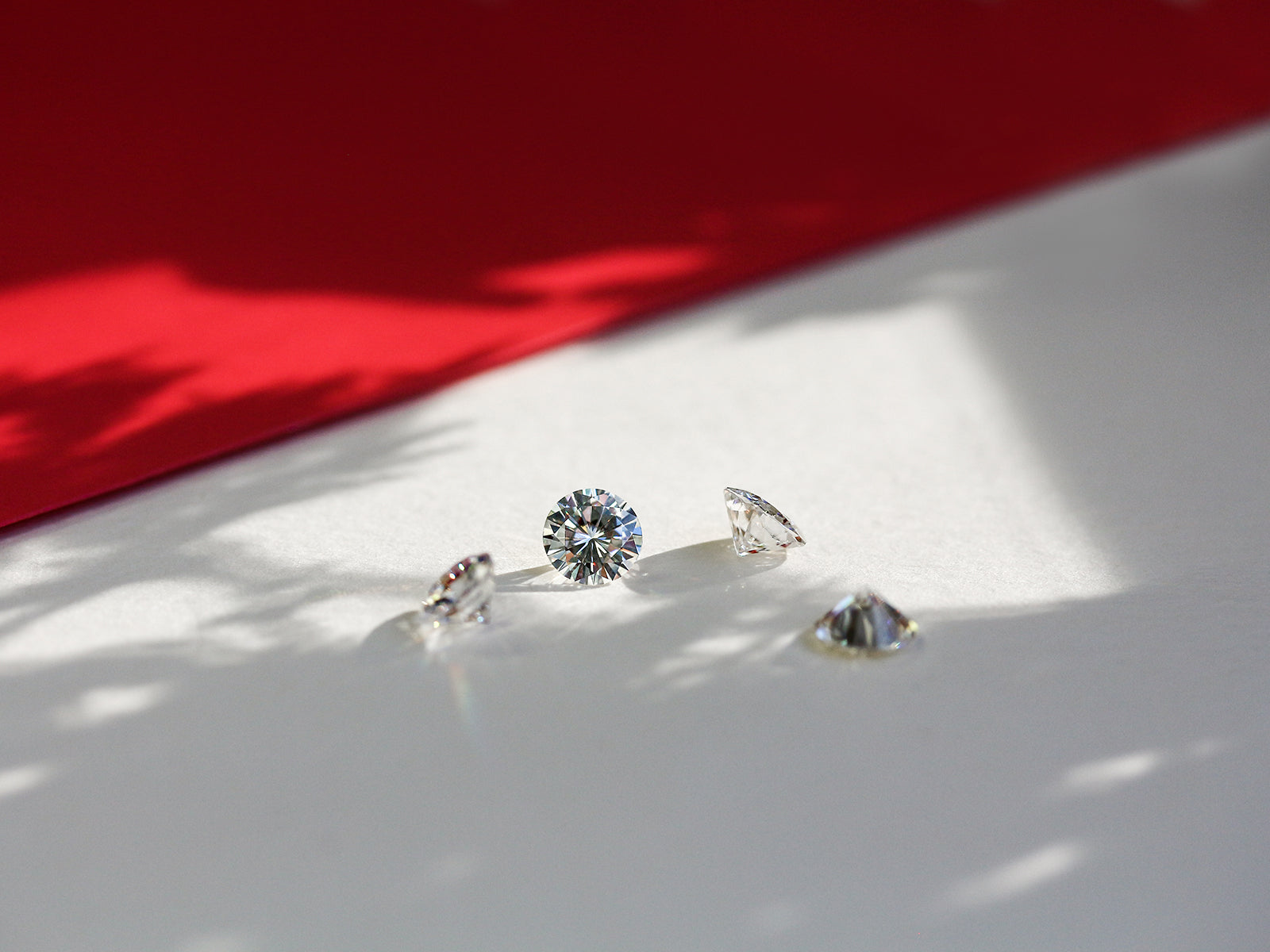loose diamonds on white table with red fabric lining