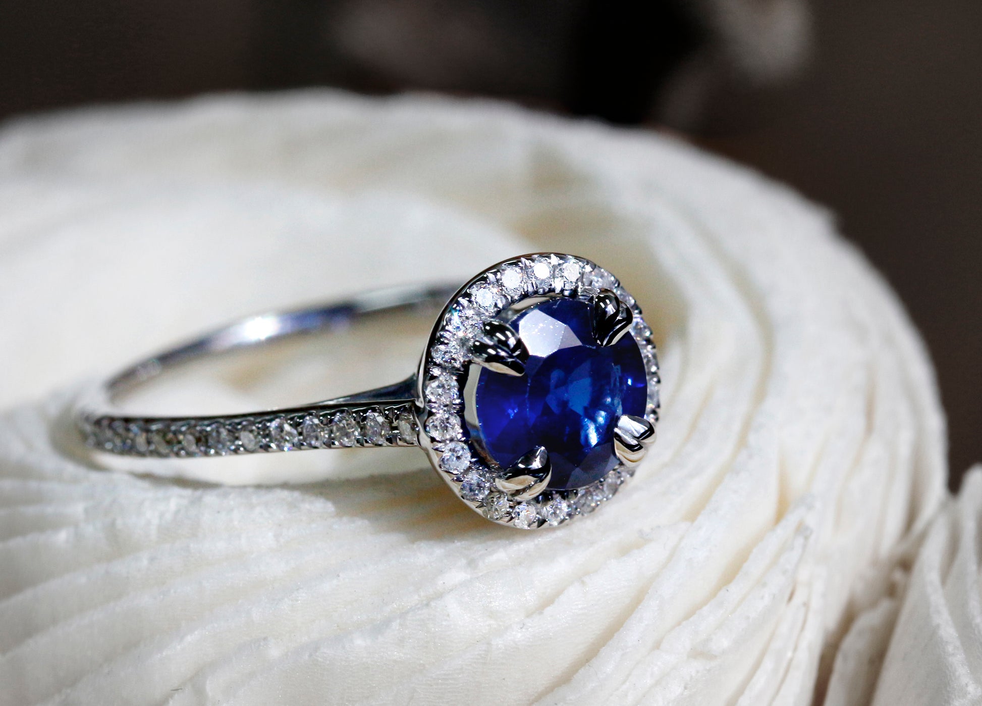 White diamonds line the halo as well as the band of the ring