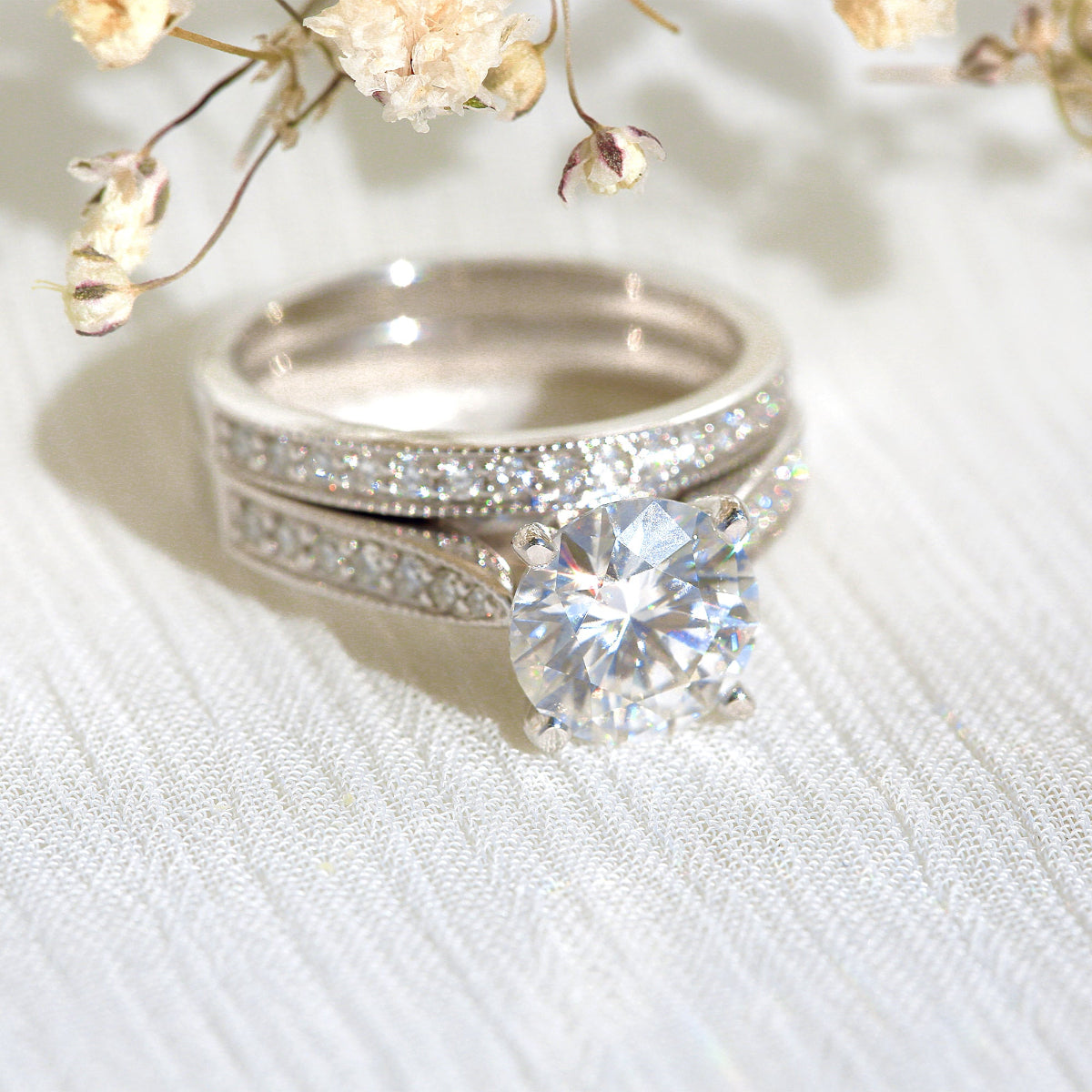 Sophie bridal set with a 2 carat round center stacked and sitting in natural lighting
