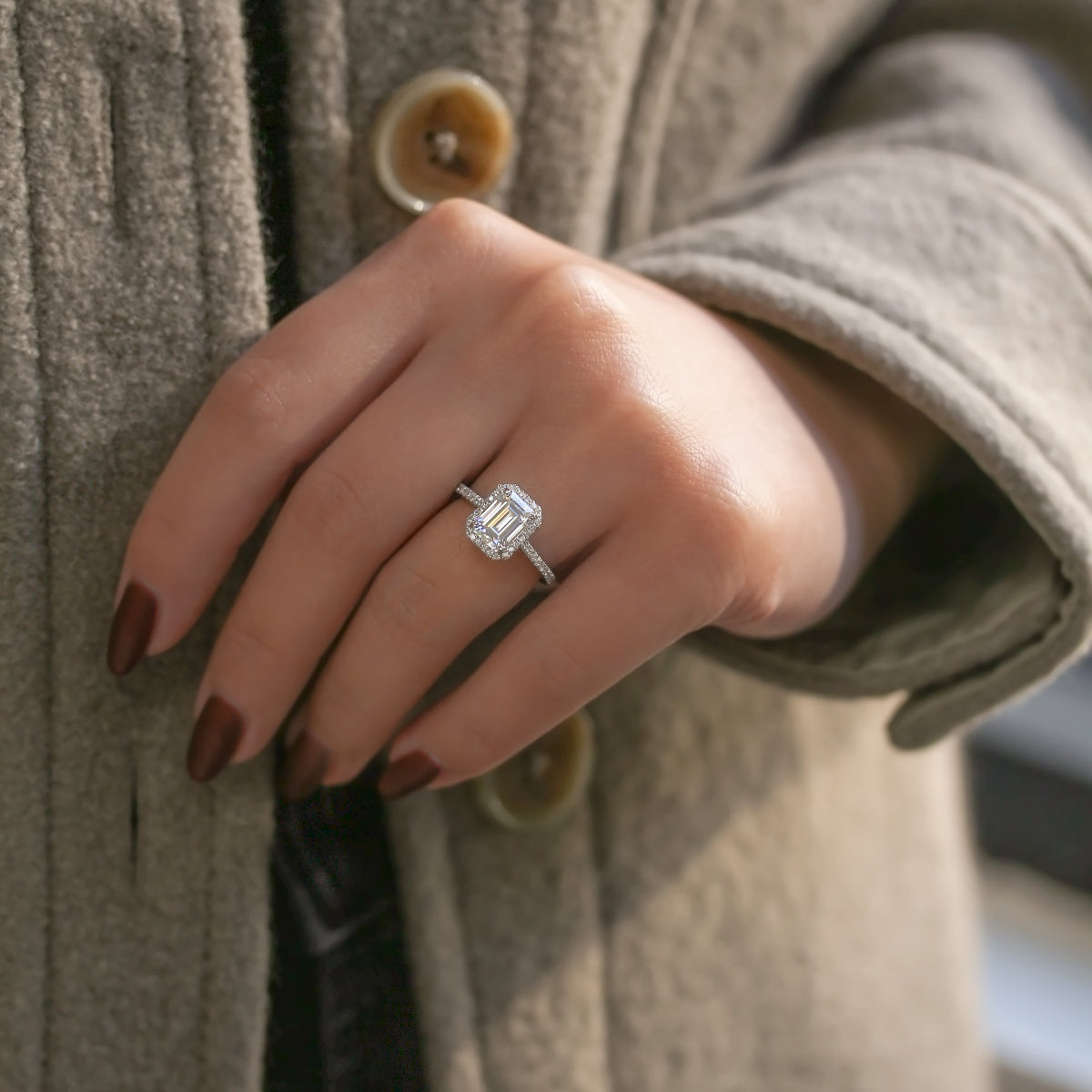 emerald shape halo ring on a hand